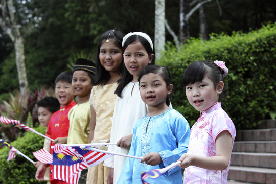 多种族儿童手持旗帜站成一排
