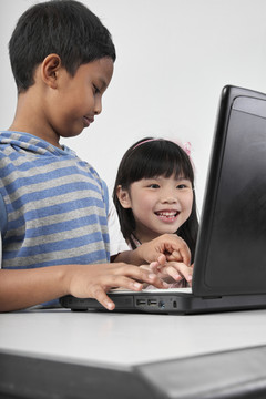 两个孩子在笔记本电脑前