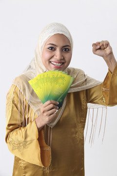 一位马来妇女正在分发绿包。