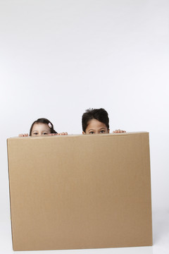 兄妹俩躲在箱子后面