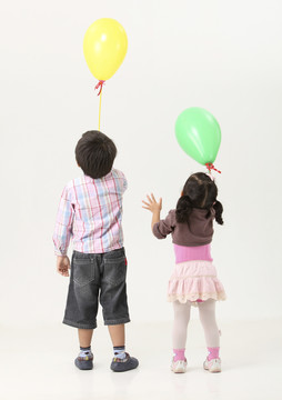 孩子们举着气球向上的后视图