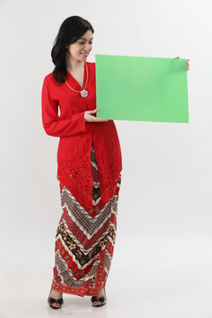 一名马来妇女手持一张空白卡片，手里拿着红色的凯巴亚牌