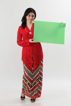 一名马来妇女手持一张空白卡片，手里拿着红色的凯巴亚牌