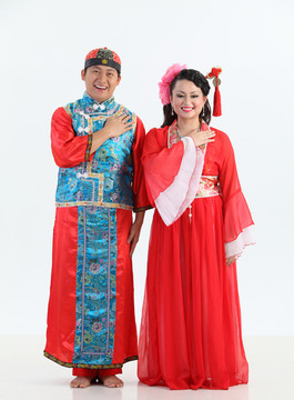 身着传统服装的中国夫妇，带欢迎标志