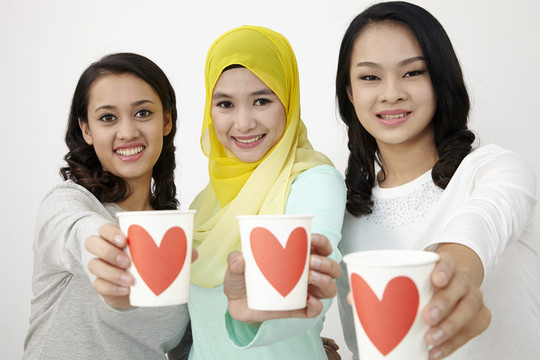 三个多种族的马来西亚人拿着爱的杯子看着镜头