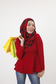 摄影棚拍摄的马来妇女拿着五颜六色的购物袋