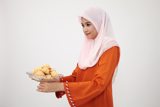 亚洲穆斯林马来妇女，图东拿着一盘巴胡卢