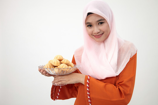 亚洲穆斯林马来妇女，图东拿着一盘巴胡卢