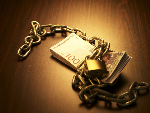 一堆马来西亚林吉特货币用链锁锁住，摄影棚拍摄