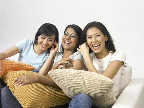 三个年轻的女人在听MP3，大笑