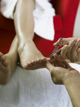 美容师为年轻女子剪脚趾甲