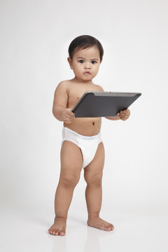 马来幼儿拿着平板电脑看着相机