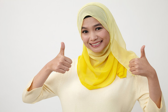 披着围巾竖起大拇指的马来妇女