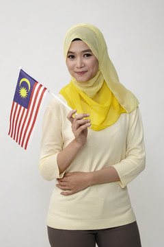 手持马来西亚小旗的马来妇女