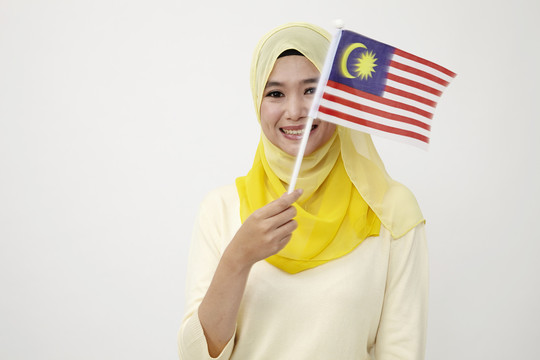 手持马来西亚小旗的马来妇女