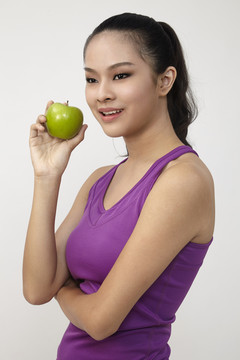 健康漂亮的中国白衣女孩手里拿着一个青苹果