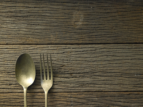 木制背景上的古董叉子和勺子