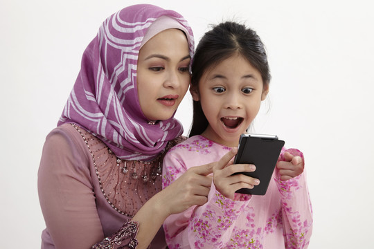 兴奋的女孩和妈妈用智能手机打视频电话的特写镜头