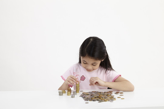 小女孩在桌子上数他的硬币