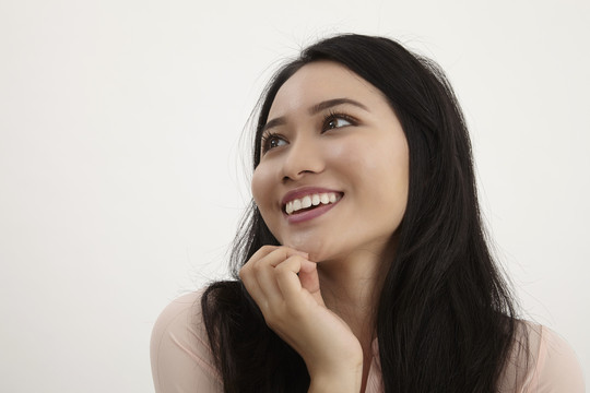 一个微笑着思考的女人抬头仰望的画像-孤立在白色的地面上