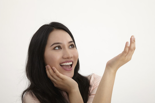 一个微笑着思考的女人抬头仰望的画像-孤立在白色的地面上