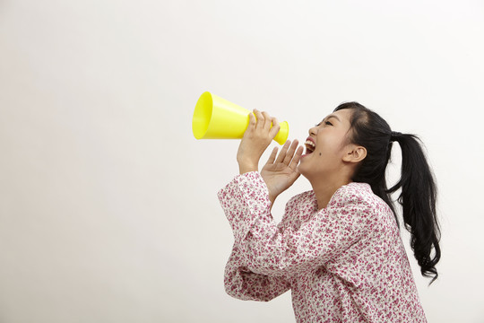 一名马来妇女拿着一个大电话大喊