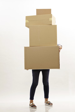 拿着一堆棕色盒子的女人她躲在盒子后面