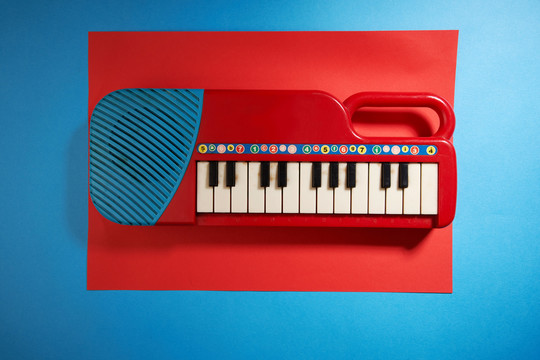 红蓝相间的玩具钢琴，背景为红蓝相间