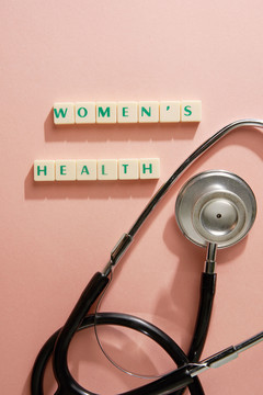 女性健康字由粉色橙色背景上的方形字母组成