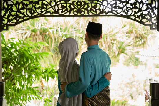 马来人夫妇穿着传统服装等待客人的实景