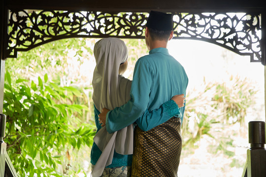 马来人夫妇穿着传统服装等待客人的实景