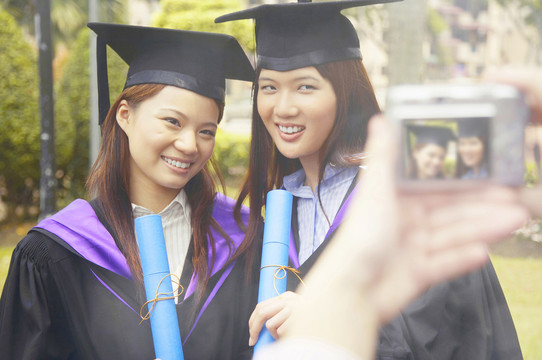 身着毕业礼服的大学生在镜头前合影