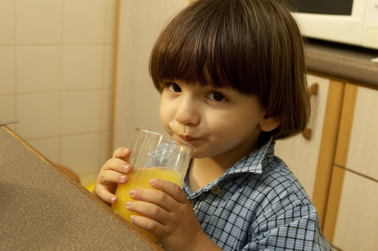 喝一杯橙汁的男孩