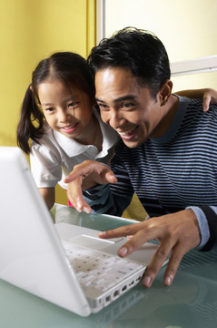 爸爸和女儿在玩电脑游戏