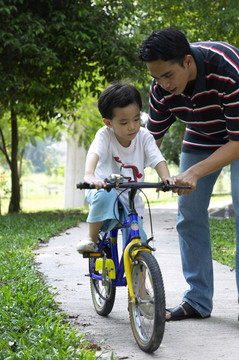 教儿子骑自行车的人