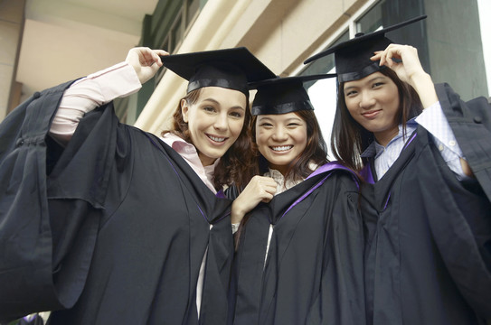 身着毕业礼服的大学生在镜头前合影