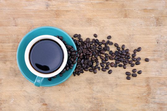 一杯黑咖啡和散落的咖啡豆