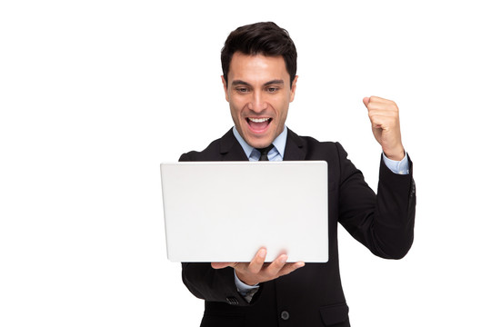 一位兴奋的商人举着笔记本电脑，在白色背景下庆祝成功，带着幸福的表情举起手臂，这是一幅男性模特的画像