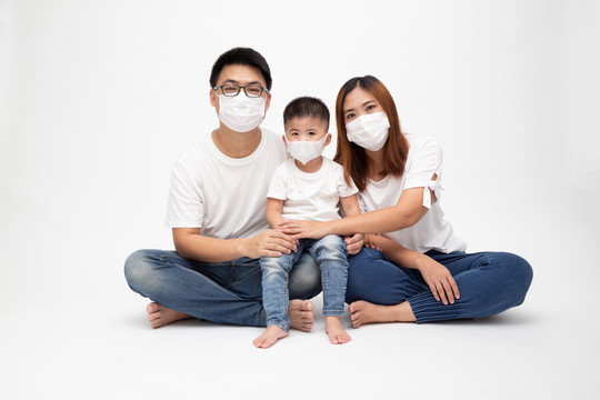 亚洲家庭戴2019冠状病毒疾病预防罩，并在地板上隔离白色背景。保护家庭免受空气污染概念