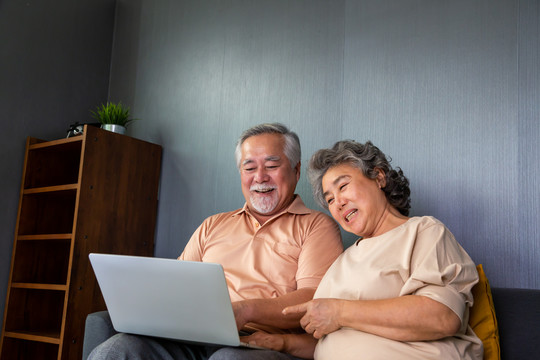 亚洲老年夫妇在笔记本电脑上视频通话聊天，老年智能技术和在线行动保持联系的概念