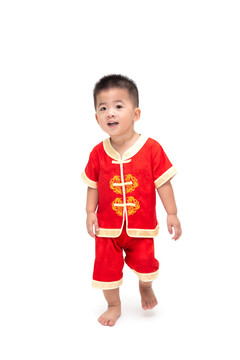 亚洲男婴站立和行走的肖像，白色背景上隔离着传统的中国服装，为中国新年概念装扮，一岁六个月婴儿模型