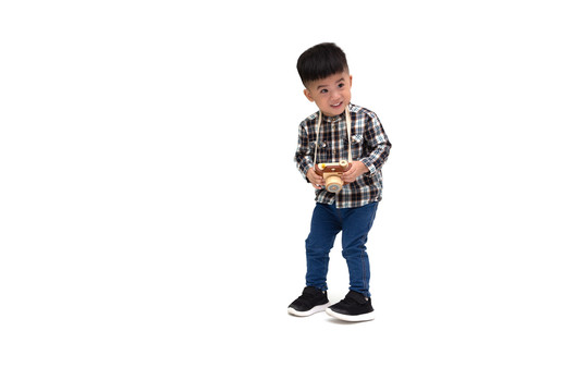 两岁一个月大的亚洲小男孩摄影师，穿着条纹衬衫，孤立地站在白色背景下，用玩具照相机拍照