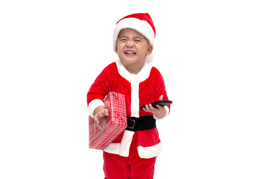 在白色背景下，亚洲男婴圣诞老人微笑着拿着圣诞礼物盒欢笑