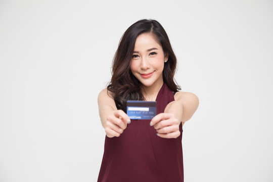 年轻美丽的亚洲女性微笑，展示，出示信用卡进行支付或支付在线业务，支付商户或作为商品、持卡人或持卡人的