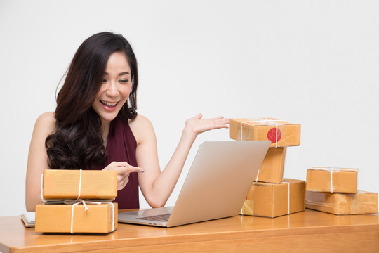 年轻的亚洲女性创业者，小型企业企业家，自由职业者，在家工作，对许多客户的订单感到兴奋，在线营销包装箱