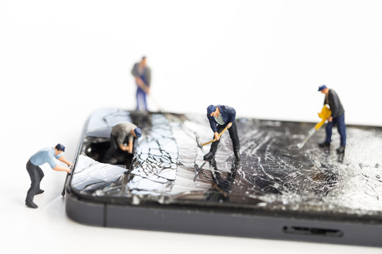 迷你技术人员正在维修因坠落、智能手机撞到街道和维修破裂的手机而导致的破损屏幕手机
