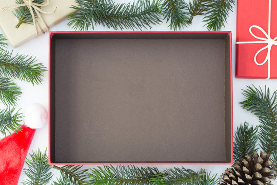 白色背景上的圣诞构图、礼品盒、松果、冷杉枝的俯视图，并打开盒子，留出空间放置产品