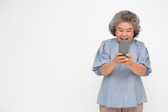 亚洲资深女性使用智能手机，在白色背景下通过手机聊天应用程序收到好消息