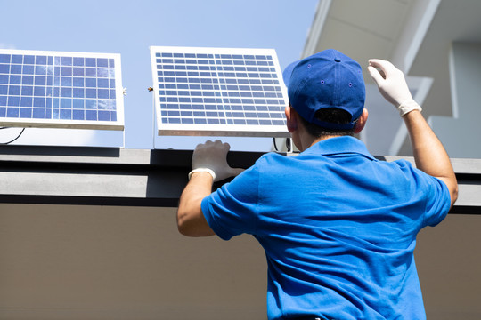 亚洲工人和技术人员正在屋顶上安装用于LED灯的太阳能光伏板。外部太阳能电池系统安装概念