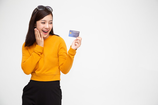 快乐的亚洲女性持有信用卡或现金预付款，支付而不是金钱，并为女士卡提供特别策划的福利概念